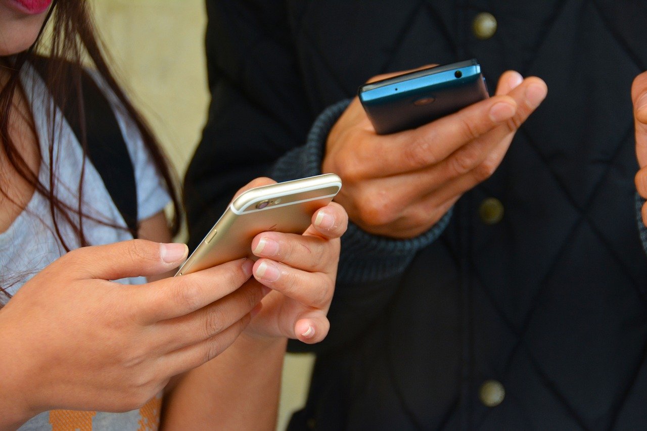 Close Up Of Two People Using Phones